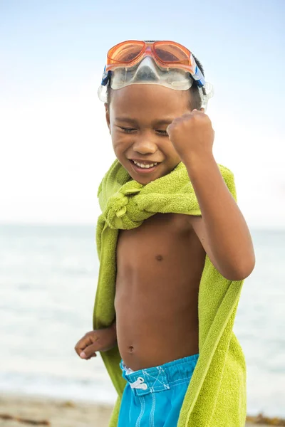 Młody chłopak gra superbohatera na plaży. — Zdjęcie stockowe