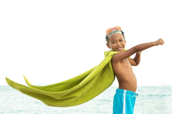 Jonge jongen superheld spelen op het strand. — Stockfoto