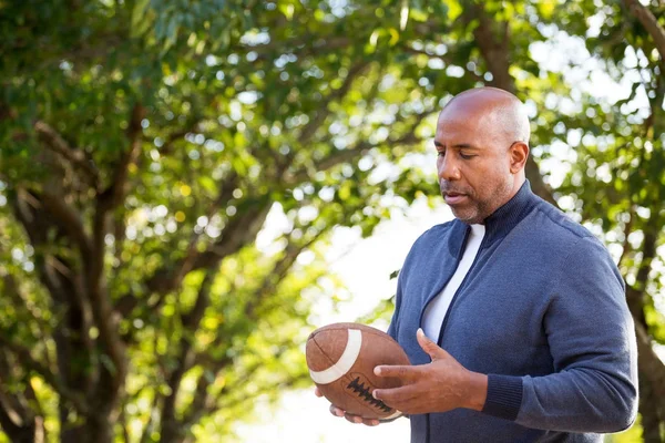 Dojrzały człowiek African American, trzymając piłki nożnej. — Zdjęcie stockowe