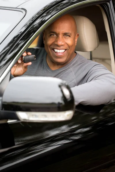 Hombre afroamericano conduciendo un coche nuevo — Foto de Stock
