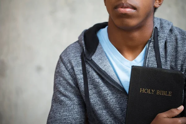 Jonge tiener op school met een Bijbel. — Stockfoto