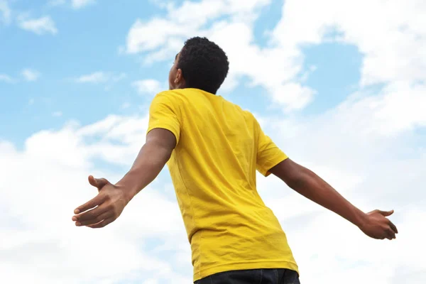 Jeune adolescent garçon avec les mains ouvertes au ciel . — Photo