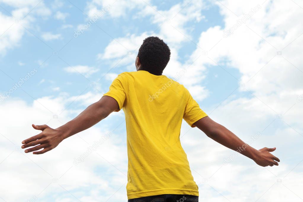Young teen boy with open hands to the sky.