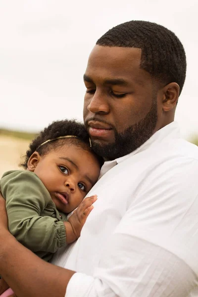 Padre afroamericano sosteniendo a su hija . — Foto de Stock