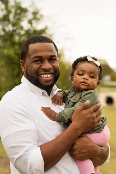 Батько афроамериканець тримає свою дочку. — стокове фото