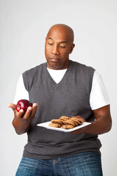 Der Mensch trifft Entscheidungen, gesunde Verse ungesund zu essen. — Stockfoto