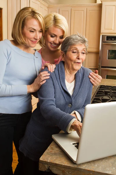 Kleindochter helpen haar grootmoeder op de computer. — Stockfoto