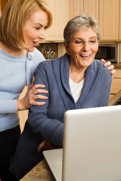 Daughter helping her mother on the computer. — Stock Photo, Image