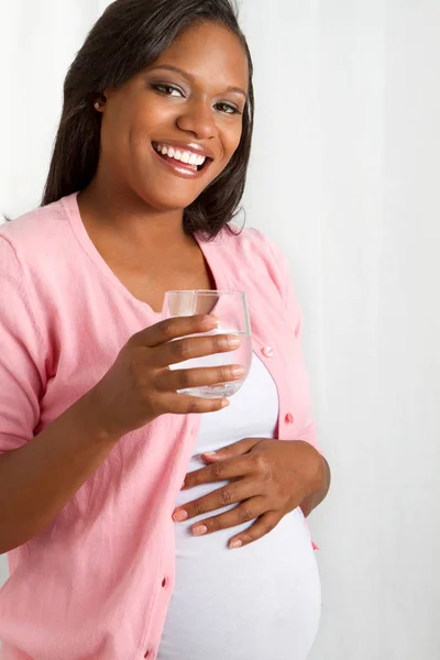 Africká americká zdravá těhotná žena pitné vody. — Stock fotografie