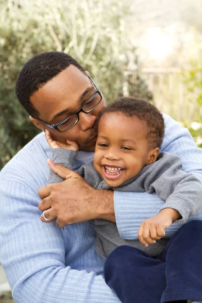 Vader knuffelen en lachen met zijn zoon. — Stockfoto