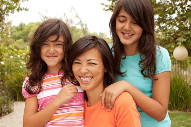 Sevgi dolu Asya anne ve kızı gülümseyen.