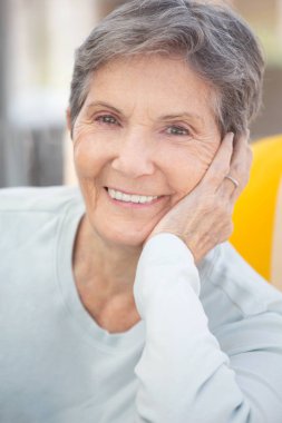 Gülümseyen bir olgun yaşlı kadın portresi.