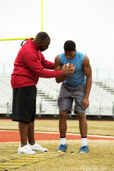 Coach training a high school athlete.