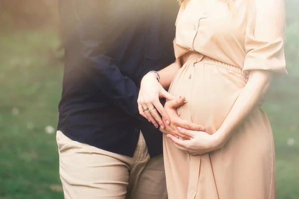 Körülvágott kép szép terhes nő és a jóképű férje, átölelve a has — Stock Fotó