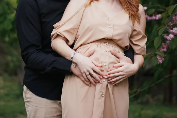 Abgeschnittenes Bild der schönen schwangeren Frau und ihres hübschen Mannes, der den Bauch umarmt — Stockfoto