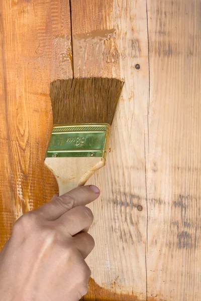 hand painting wooden wall with brush
