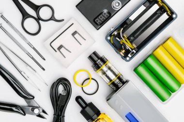 Beyaz arka planda modern buharlaşma cihazının bakımı ve montajı için araç gereç kiti. sökülmüş tüp mod, piller, buhar cihazı, uygun şişe, usb kablosu, cımbız, makas, makas...