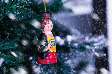 Süslü bir Noel ağacına asılmış Rus ahşap oyuncağı. Kar fırtınası etkisi.