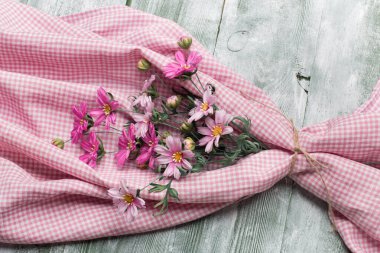 Yapay kozmos bipinnatus yeşil ahşap masada.