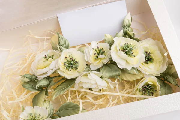 decoration artificial flowers in gift box with card. shot in studio on white background