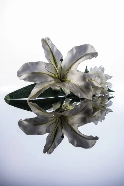 Dekoration Künstliche Lilie Auf Dunklem Hochglanztisch Auf Weißem Hintergrund — Stockfoto