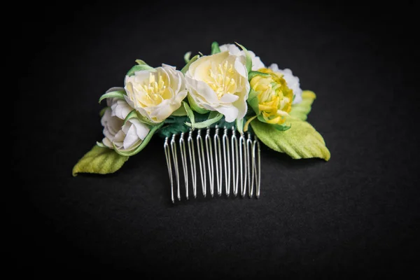 Wedding hair pin decorated with artificial flowers on black background