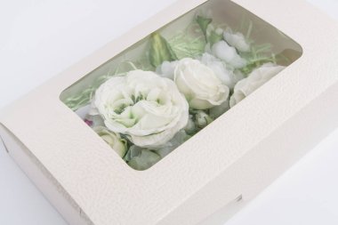 Beyaz arkaplandaki kutuda yapay çiçek