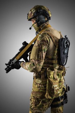 Saldırı tüfeği tutan asker. Üniforma Rusya Federasyonu 'nun özel hizmetlerine uyuyor. Stüdyoda çekilmiş. Gri arkaplanda kırpma yolu ile izole edilmiş