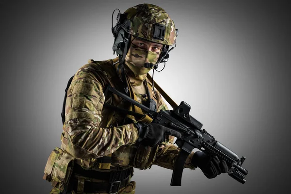 Saldırı tüfeği tutan asker. Üniforma Rusya Federasyonu 'nun özel hizmetlerine uyuyor. Stüdyoda çekilmiş. Gri arkaplanda kırpma yolu ile izole edilmiş