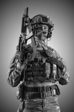 Saldırı tüfeği tutan asker. Üniforma Rusya Federasyonu 'nun özel hizmetlerine uyuyor. Stüdyoda çekilmiş. Gri arkaplanda kırpma yolu ile izole edilmiş (siyah ve beyaz)