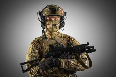 Saldırı tüfeği tutan asker. Üniforma Rusya Federasyonu 'nun özel hizmetlerine uyuyor. Stüdyoda çekilmiş. Gri arkaplanda kırpma yolu ile izole edilmiş