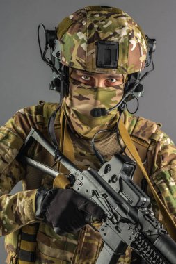 Saldırı tüfeği tutan asker. Üniforma Rusya Federasyonu 'nun özel hizmetlerine uyuyor. Stüdyoda çekilmiş. Gri arkaplanda kırpma yolu ile izole edilmiş