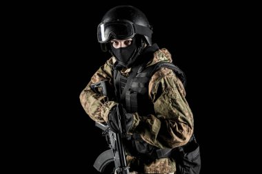 Bir asker saldırı tüfeği tutuyor. Üniforma Rusya Federasyonu 'nun FSB özel hizmetlerine uyuyor. Stüdyoda çekilmiş. Siyah arkaplanda kırpma yolu ile izole edildi