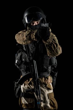 Bir asker saldırı tüfeği tutuyor. Üniforma Rusya Federasyonu 'nun FSB özel hizmetlerine uyuyor. Stüdyoda çekilmiş. Siyah arkaplanda kırpma yolu ile izole edildi