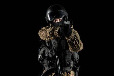 Bir asker saldırı tüfeği tutuyor. Üniforma Rusya Federasyonu 'nun FSB özel hizmetlerine uyuyor. Stüdyoda çekilmiş. Siyah arkaplanda kırpma yolu ile izole edildi