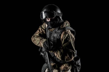 Bir asker saldırı tüfeği tutuyor. Üniforma Rusya Federasyonu 'nun FSB özel hizmetlerine uyuyor. Stüdyoda çekilmiş. Siyah arkaplanda kırpma yolu ile izole edildi
