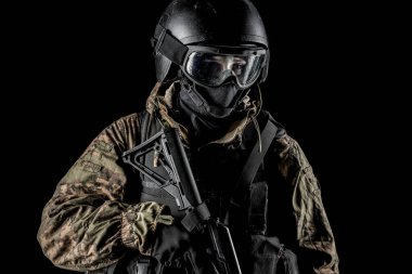 Bir asker saldırı tüfeği tutuyor. Üniforma Rusya Federasyonu 'nun FSB özel hizmetlerine uyuyor. Stüdyoda çekilmiş. Siyah arkaplanda kırpma yolu ile izole edildi