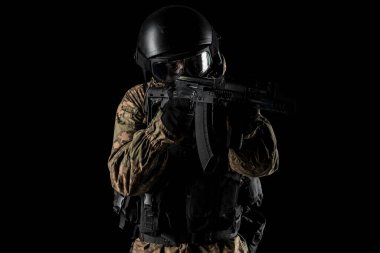 Bir asker saldırı tüfeği tutuyor. Üniforma Rusya Federasyonu 'nun FSB özel hizmetlerine uyuyor. Stüdyoda çekilmiş. Siyah arkaplanda kırpma yolu ile izole edildi