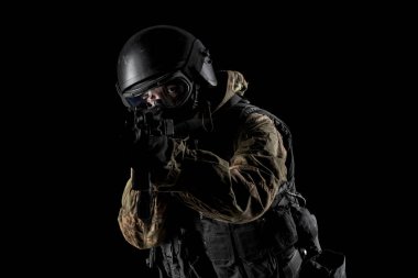 Bir asker saldırı tüfeği tutuyor. Üniforma Rusya Federasyonu 'nun FSB özel hizmetlerine uyuyor. Stüdyoda çekilmiş. Siyah arkaplanda kırpma yolu ile izole edildi