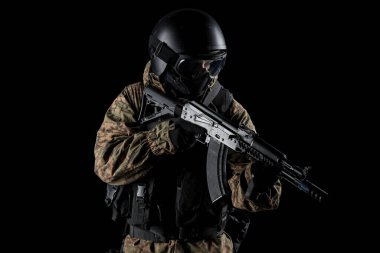 Bir asker saldırı tüfeği tutuyor. Üniforma Rusya Federasyonu 'nun FSB özel hizmetlerine uyuyor. Stüdyoda çekilmiş. Siyah arkaplanda kırpma yolu ile izole edildi