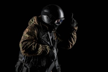 Bir asker saldırı tüfeği tutuyor. Üniforma Rusya Federasyonu 'nun FSB özel hizmetlerine uyuyor. Stüdyoda çekilmiş. Siyah arkaplanda kırpma yolu ile izole edildi