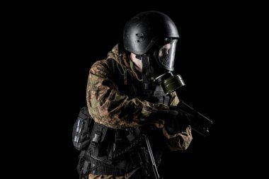 Bir asker saldırı tüfeği tutuyor. Üniforma Rusya Federasyonu 'nun FSB özel hizmetlerine uyuyor. Stüdyoda çekilmiş. Siyah arkaplanda kırpma yolu ile izole edildi
