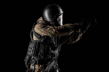 Bir asker saldırı tüfeği tutuyor. Üniforma Rusya Federasyonu 'nun FSB özel hizmetlerine uyuyor. Stüdyoda çekilmiş. Siyah arkaplanda kırpma yolu ile izole edildi