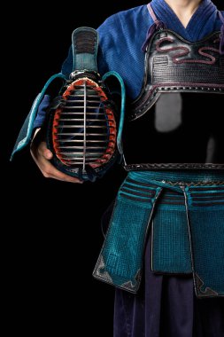 Geleneksel Kendo zırhlı, kasklı bir erkek. Stüdyoda çekilmiş. Siyah arkaplanda izole 