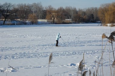 Kız donmuş bir nehirde kayak yapıyor