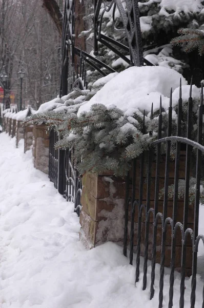 Древний кованый забор из металла и камня зимой — стоковое фото