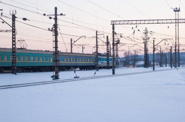 Yolcu treni karla kaplı raylar kış akşamları yayılıyor..