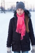 Portrét dospívající dívka v černé bundě a růžový šátek na pozadí sněhu zimní.