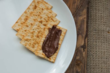 ahşap bir arka planda beyaz bir plaka üzerinde çeşitli çerezler kraker