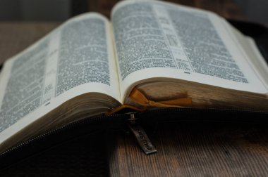 Incil açık kitap ahşap bir yüzey üzerinde yatıyor.